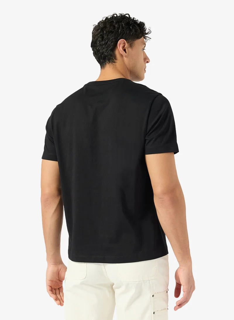 جس تيشيرت بأكمام قصيرة وياقة دائرية وطبعة شعار